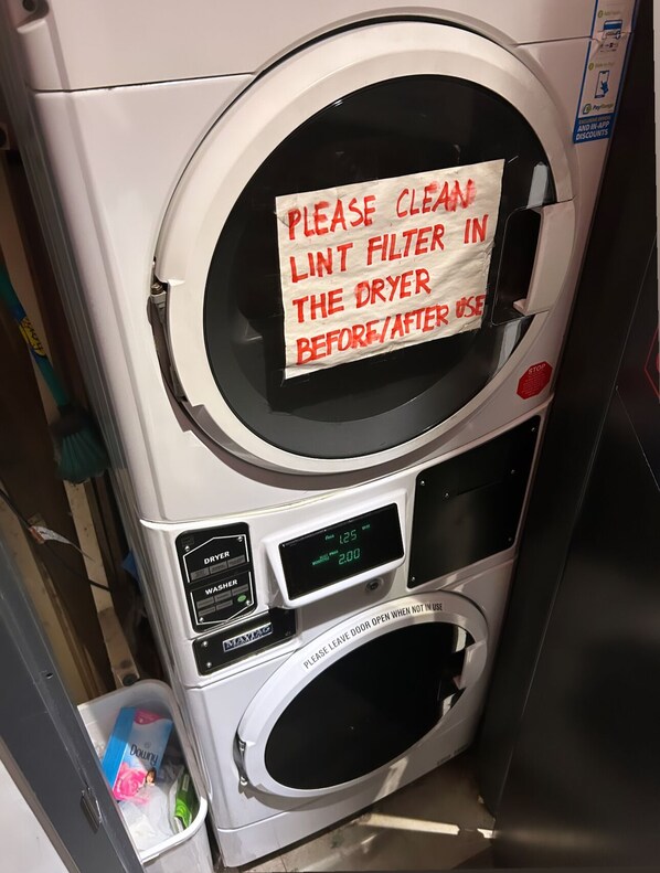 A front-loading washing machine with a sign instructing to clean the lint filter before/after use. - Cozy Stay in NYC!! (New York)