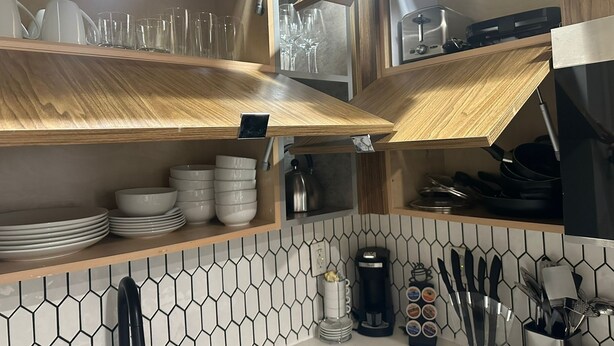 A kitchen with wooden shelves, a coffee maker, and a knife block. - Cozy Stay in NYC!! (New York)