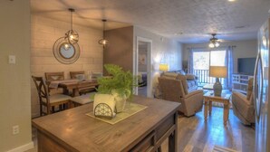 Un salón espacioso con una mesa de comedor de madera, asientos cómodos y un amplio ventanal que proporciona luz natural.