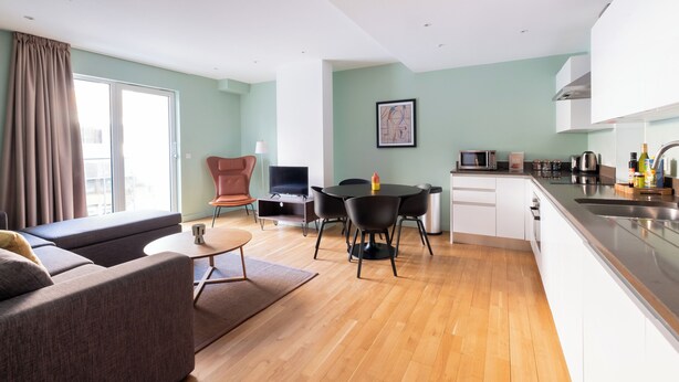 A modern apartment with a living room, dining area, and kitchen. - Native Victoria (London)