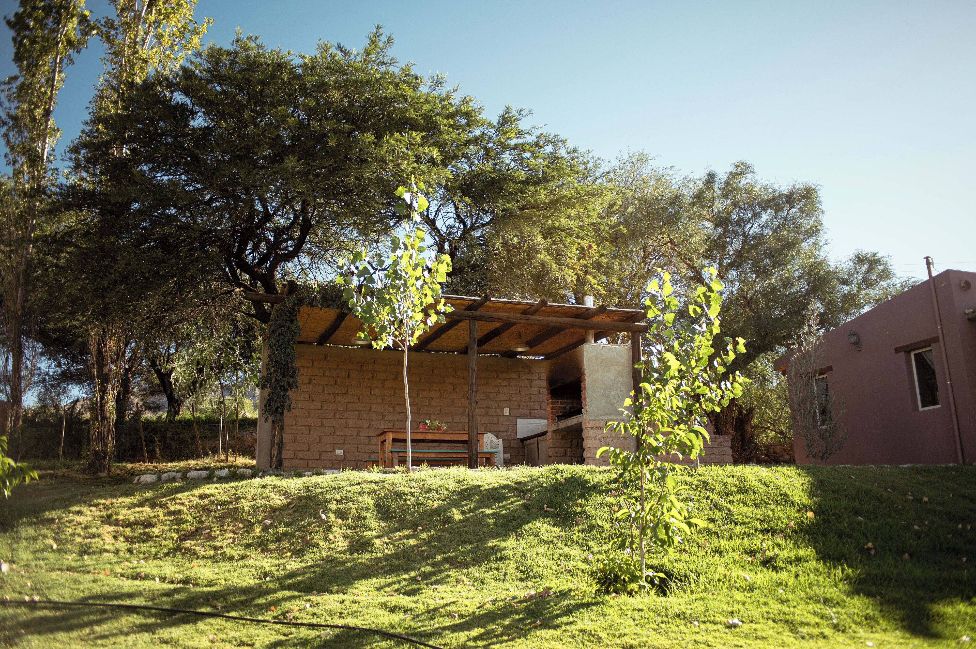 A brick building with a covered patio area, a bench, and a small table.