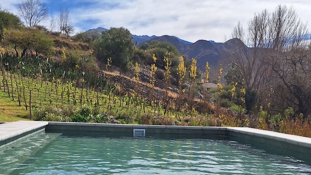 A clear pool with a view of a mountainous landscape. - Loma Puskana - Hostería (Cachi)