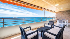 An outdoor seating area with wicker furniture and a view of the ocean. - Principado Arena 20 Deluxe Apartment Levante Beach (Benidorm)