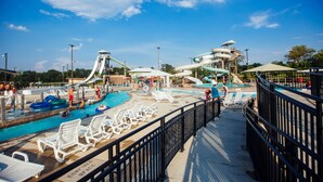 A water park with multiple slides and a pool area with lounge chairs. - Unique Dwtwn+Lake & Trails (Rogers)