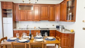 A kitchen with wooden cabinets, a dining table set for four, and a chandelier.