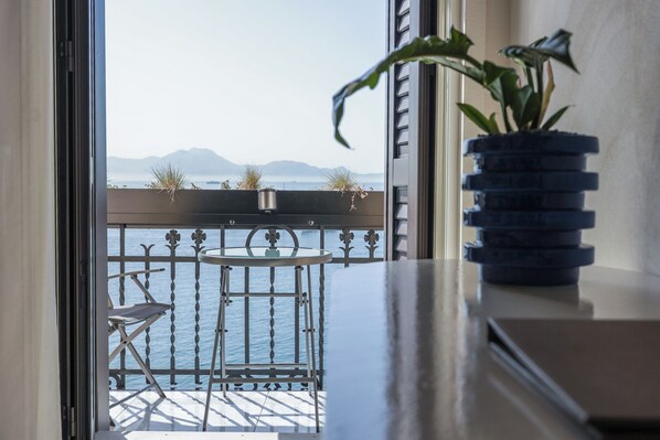 Habitación Deluxe, balcón, vista al mar | Minibar, caja de seguridad en la habitación y escritorio 