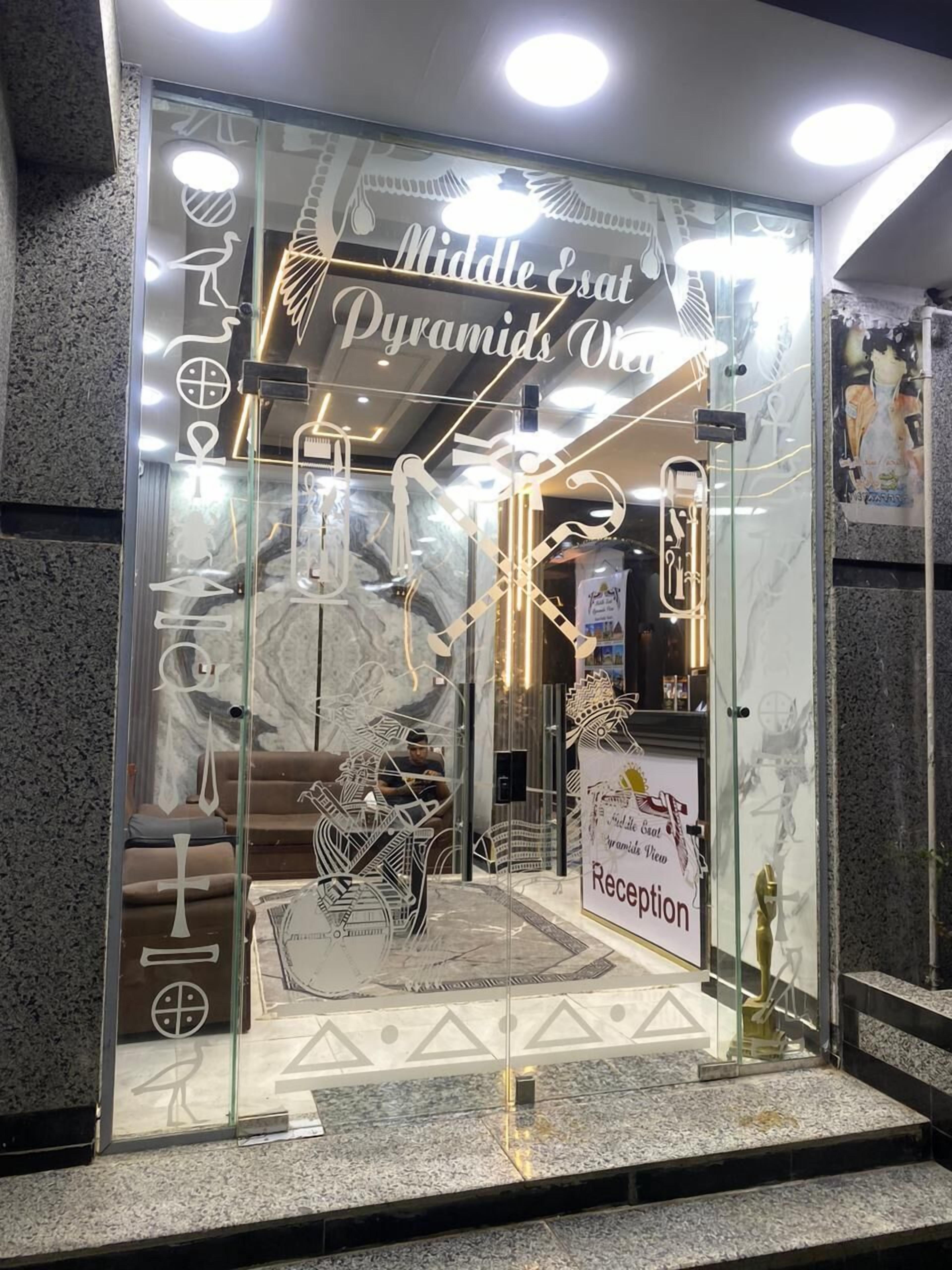 Una zona d'entrada amb façana de vidre, decoració amb temàtica egípcia i un rètol que diu "Middle East Pyramids One".