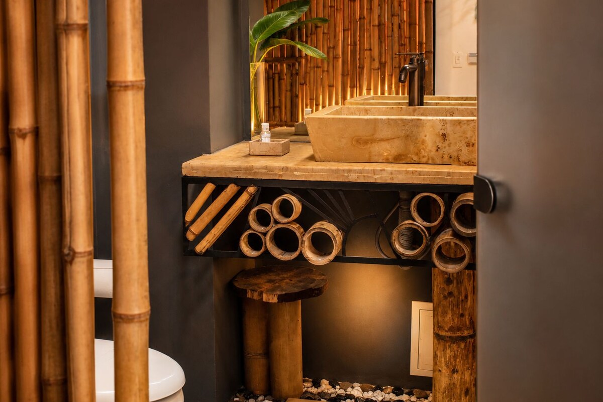 A bathroom with a bamboo-themed design, including a sink, toilet, and decorative bamboo elements.