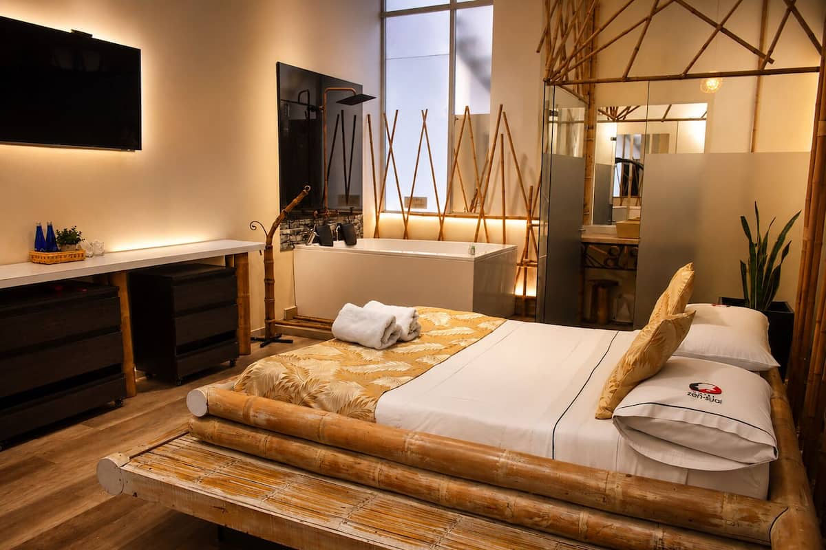 A modern room with a bed, desk, and bathroom.