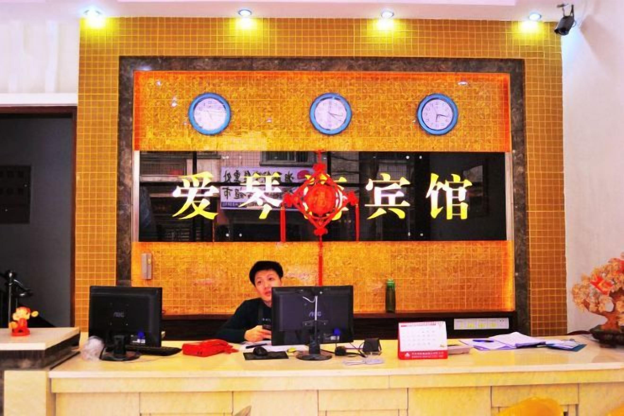 A reception desk with a digital clock, a red lantern decoration, and a sign with Chinese characters.