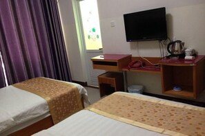 A hotel room with two beds, a desk, a television, and a window with curtains. - Aiqing Island Motel (Sanya)