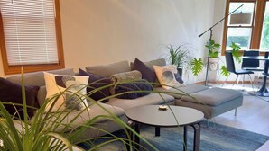 Una sala de estar moderna con sofá, mesa de centro y plantas en macetas.