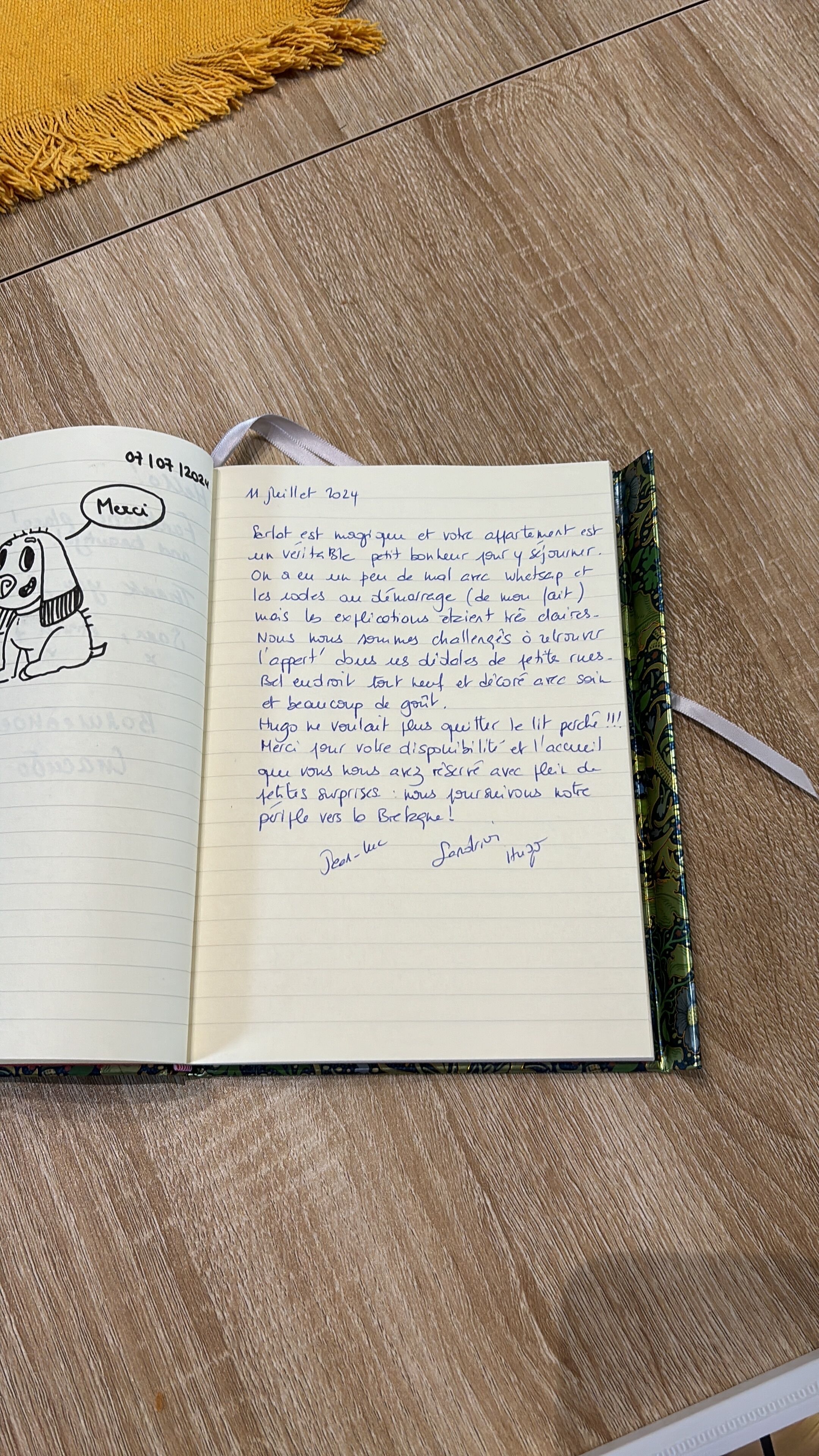 An open notebook with handwritten text and a cartoon character on the left page.