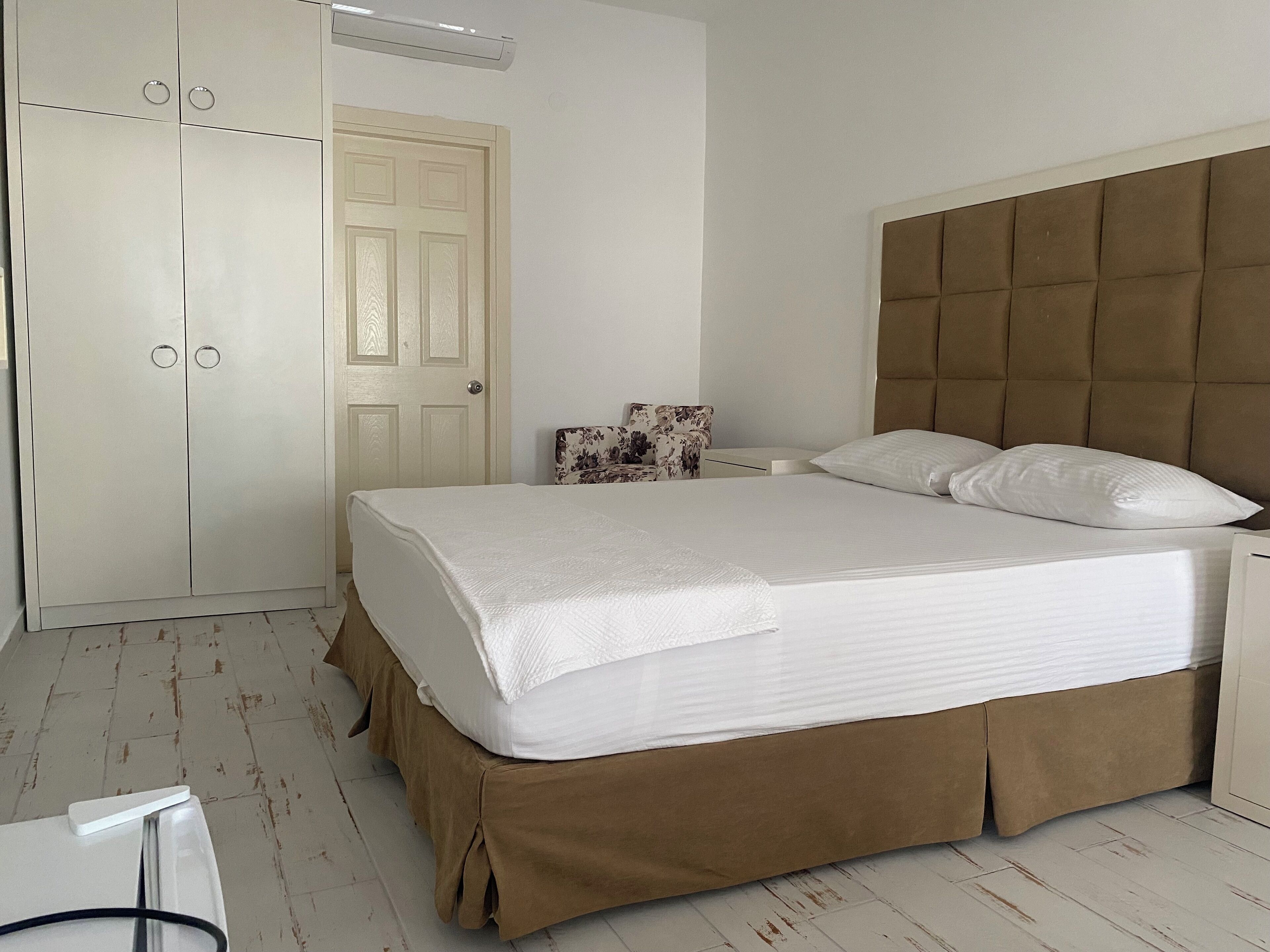 A bedroom with a bed, a wardrobe, and a nightstand.