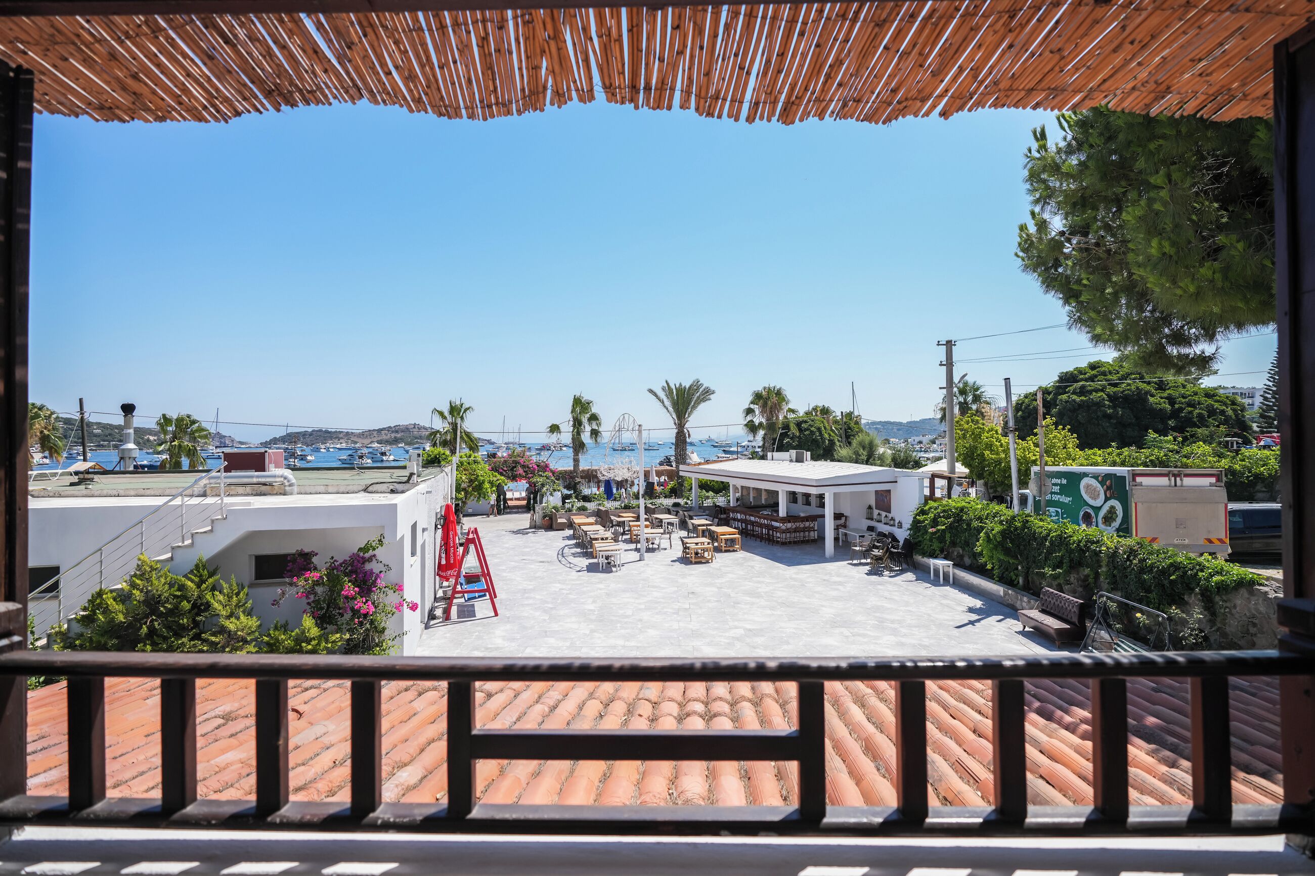 A terrace with outdoor seating, a view of the sea, and a restaurant area.