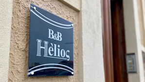 En skylt på en byggnadens vägg med texten ”B&B Hélios”.