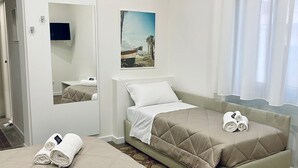 Ett hotellrum med en säng, en soffa, en tv och en tavla på väggen.