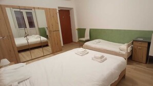 A bedroom with two beds, a desk, a mirror, and a wardrobe. - Aria di Sale Hostel (Trieste)