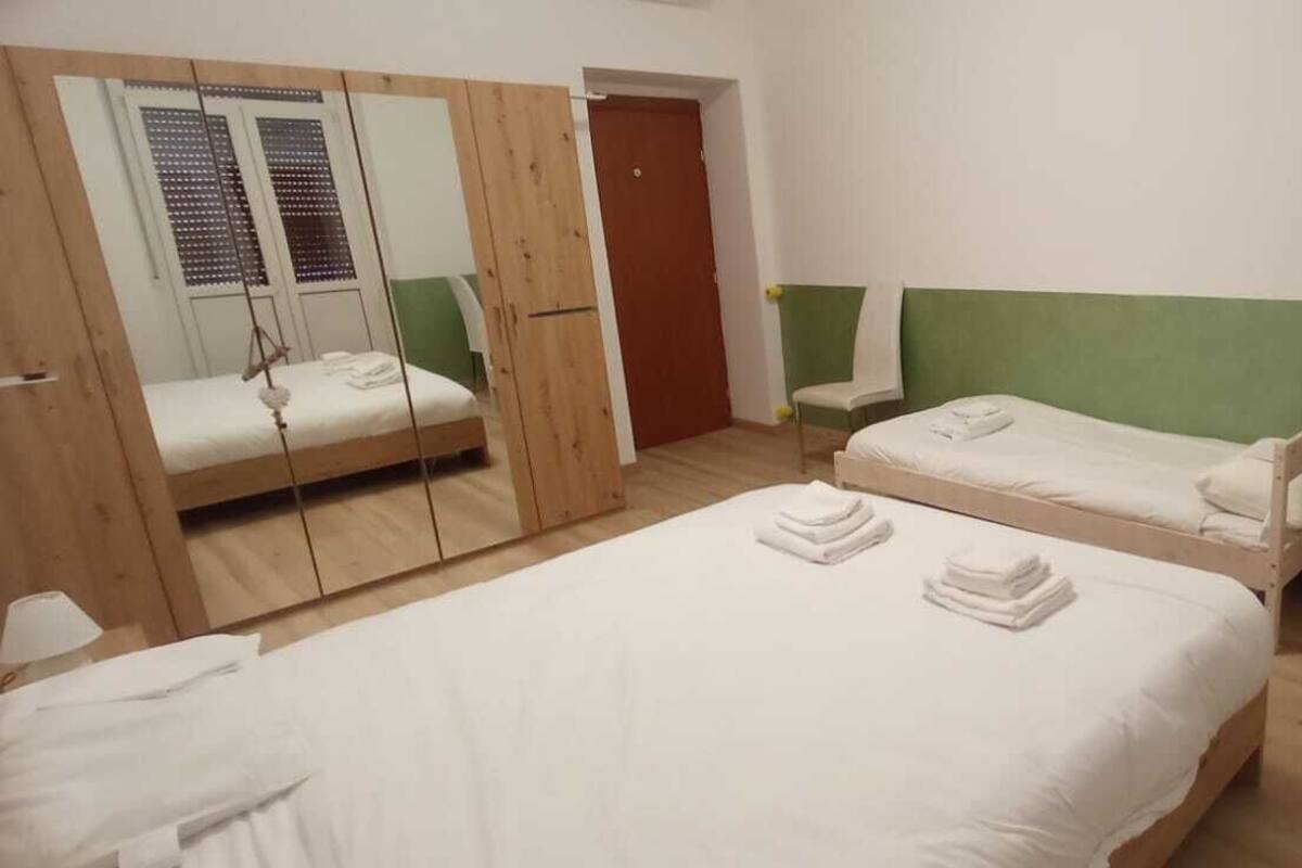 Une chambre avec deux lits, un bureau, un miroir et une armoire.