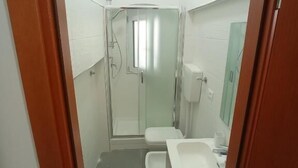 A compact bathroom with a shower, toilet, and sink. - Aria di Sale Hostel (Trieste)