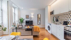 A modern apartment with a dining area, kitchen, and living space.
