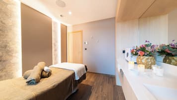 Relax in a serene space with a neatly made bed, bedside table, and candles.