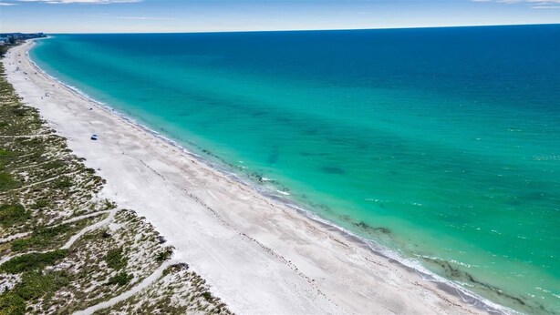 An aerial view of a beach with clear turquoise waters and a sandy shoreline. - Turquoise Gem 1st Floor [no stairs] BEACH - TOP EATS - Longboat KeyFL (Longboat Key)