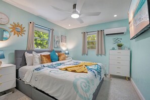 A bedroom with a bed, nightstands, a dresser, a ceiling fan, and artwork on the walls. - Turquoise Gem 1st Floor [no stairs] BEACH - TOP EATS - Longboat KeyFL (Longboat Key)