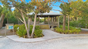 A gazebo with a wooden deck and stairs leading up to it, surrounded by trees and plants. - Turquoise Gem 1st Floor [no stairs] BEACH - TOP EATS - Longboat KeyFL (Longboat Key)