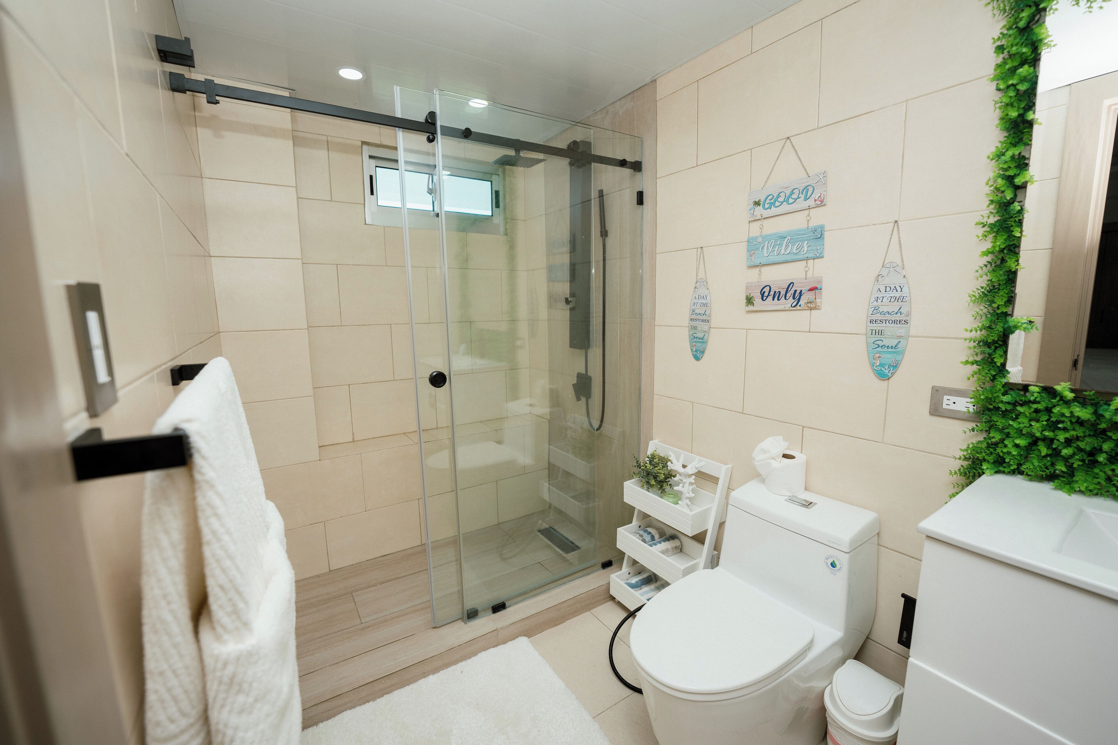 Une salle de bain moderne avec une douche à parois de verre, des toilettes et un lavabo.