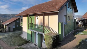 A two-story house with a sloped roof, a balcony, and a small front yard. - Domaine des Chênes Rouges - Appt 3 étoiles pour 4p dans chalet (Gérardmer)