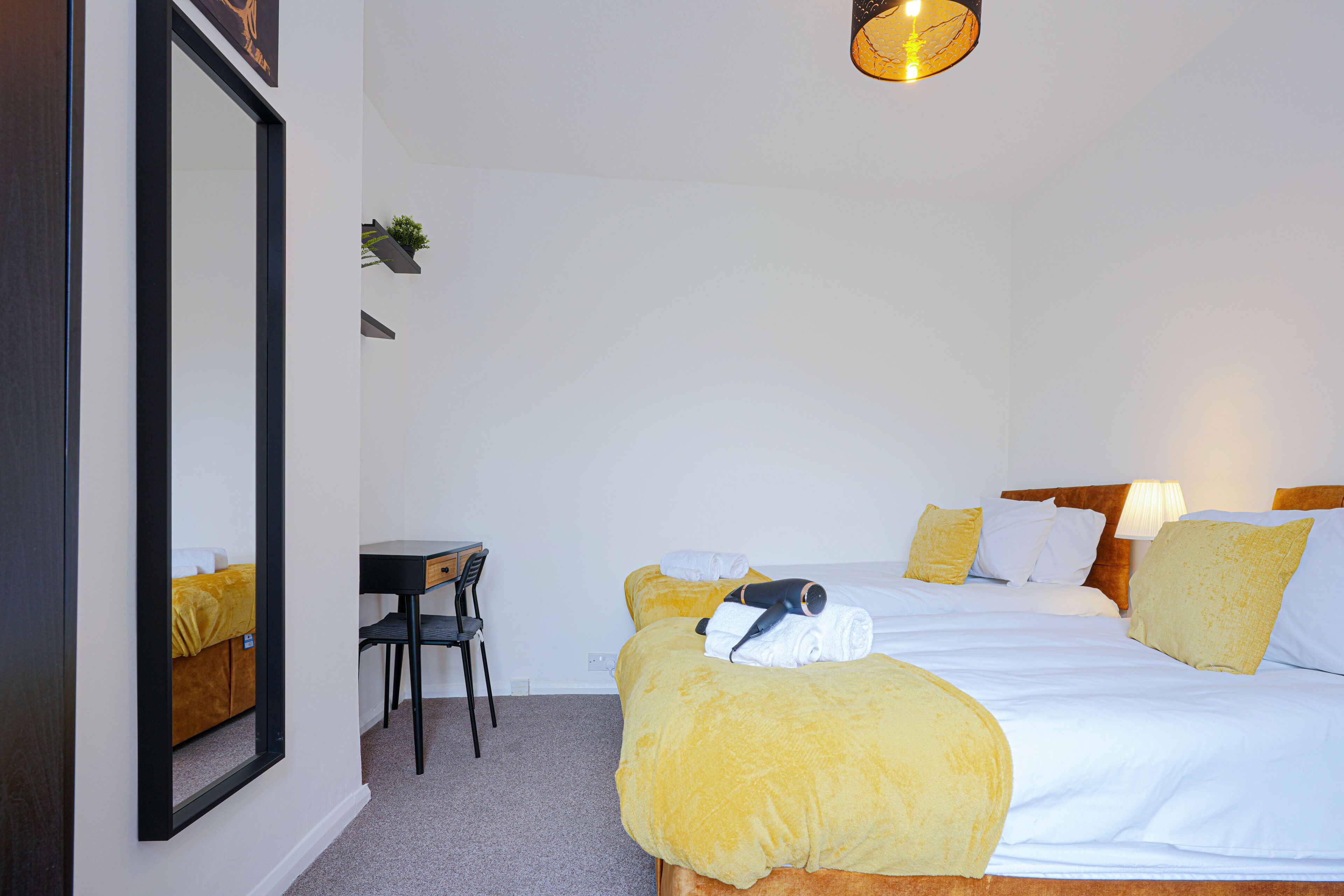 A hotel room with a bed, a desk, and a chair.