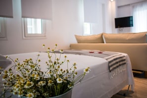 Une chambre d’hôtel avec un lit, un téléviseur fixé au mur et une fenêtre.