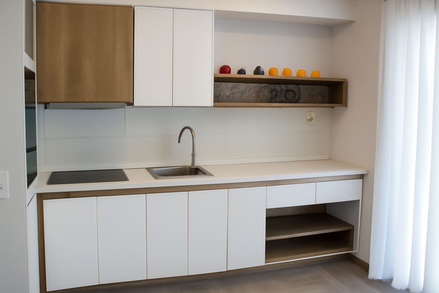 A modern kitchen with white cabinets, a stainless steel sink, and a wooden countertop.