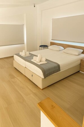 A modern bedroom with a large bed, a bedside table, and a small round table.