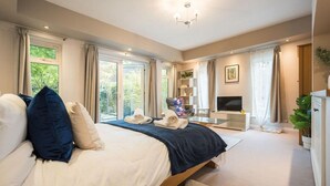 A bedroom with a bed, a TV, a desk, and a plant. - Cozy City Retreat in Bristol With Parking & Patio (Bristol)