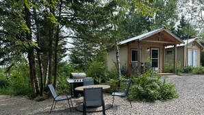 A rustic cabin with a gravel driveway, surrounded by trees. - Cabin #3 centrally located to beaches, golfing and the Confederation Trail! (Mount Stewart)