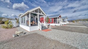 A row of cabins with a gravel driveway and a clear sky.