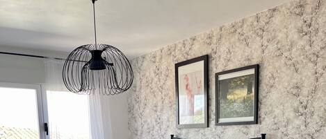 Un dormitorio con cama, mesita de noche, cómoda y ventana con cortinas.