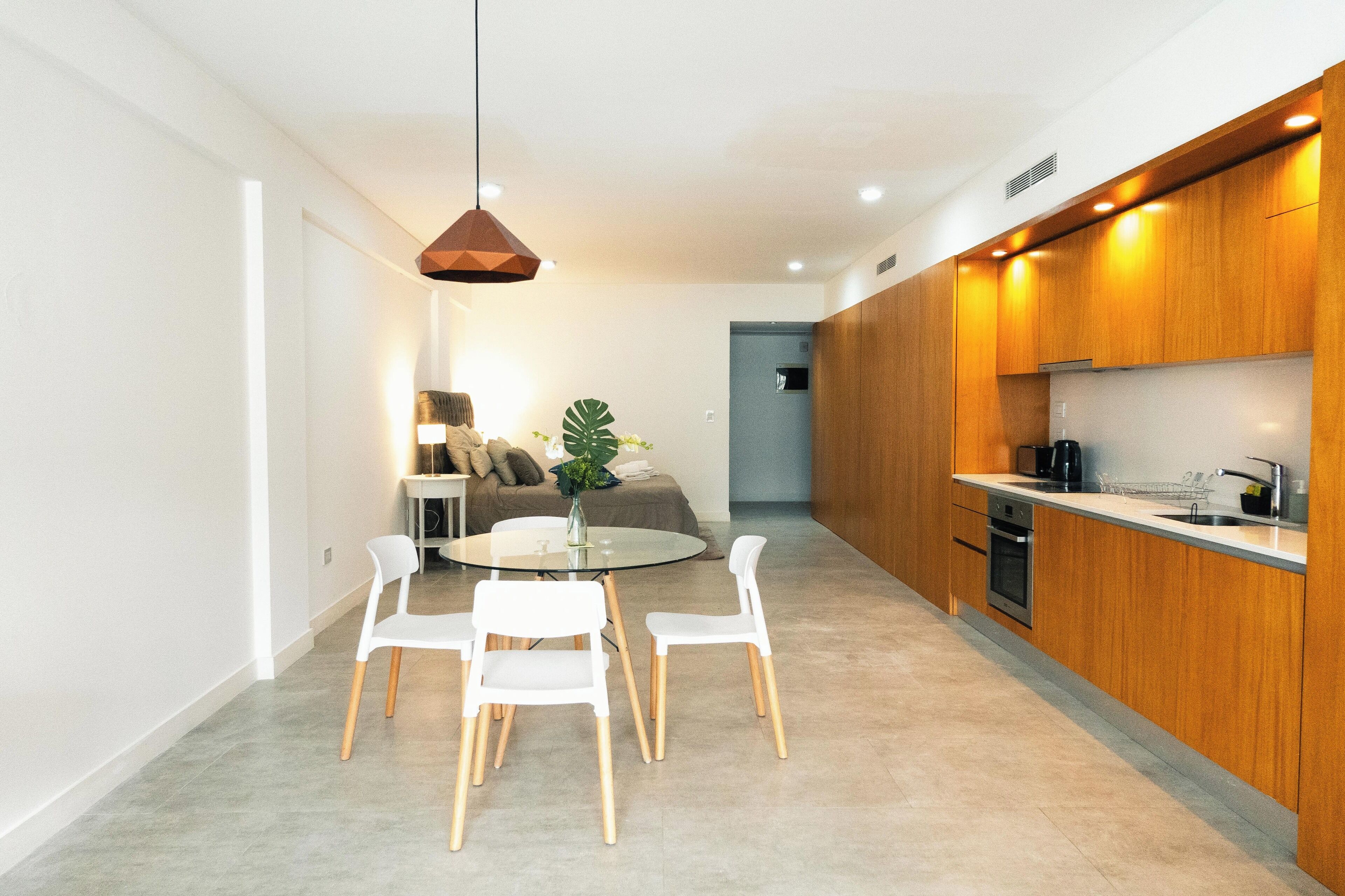 Une cuisine moderne avec des meubles en bois, un four encastré et un évier en acier inoxydable.