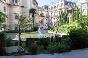 A courtyard with a fountain, surrounded by lush greenery and classical architecture. - BT Homes - Palacio Paz (Buenos Aires)