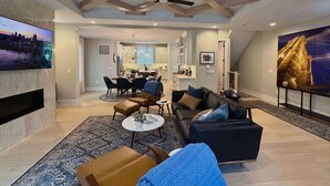 Un salon moderne avec une cheminée, un téléviseur et un coin repas.
