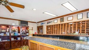Ein Empfangsbereich mit Holztresen, Deckenventilator und Wandvitrine.