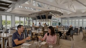Un comedor espacioso con techos altos y ventanas grandes, que ofrece luz natural y vistas al exterior.