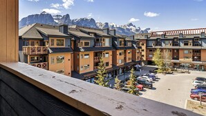 Et hotel med flere etager, altaner og udsigt til sneklædte bjerge.