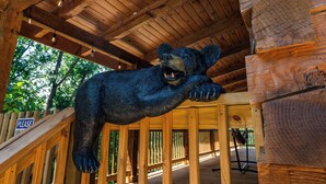 Eine Holzhütte mit einer Bärenskulptur, die von der Decke hängt.