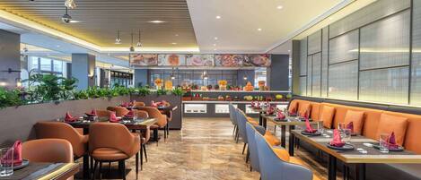A modern restaurant with a long counter, multiple seating areas, and a central bar.