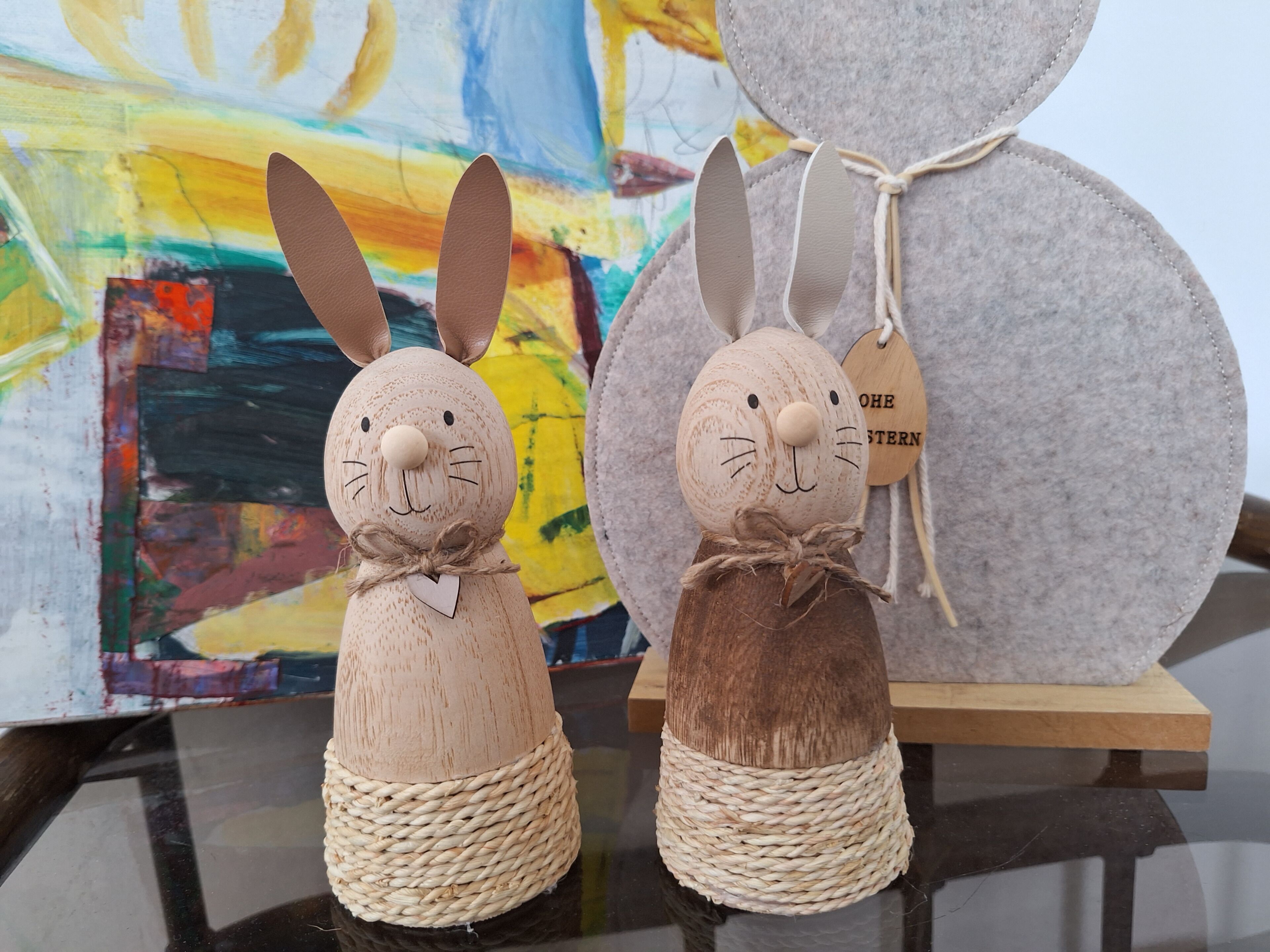Two handcrafted rabbit figures with woven bases, one with a heart-shaped bow and the other with a tag.