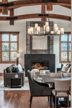 A spacious living room with a fireplace, a dining area, and a large window. - Vail Beaver Creek Home Unbelievable Mountain Views (Avon)
