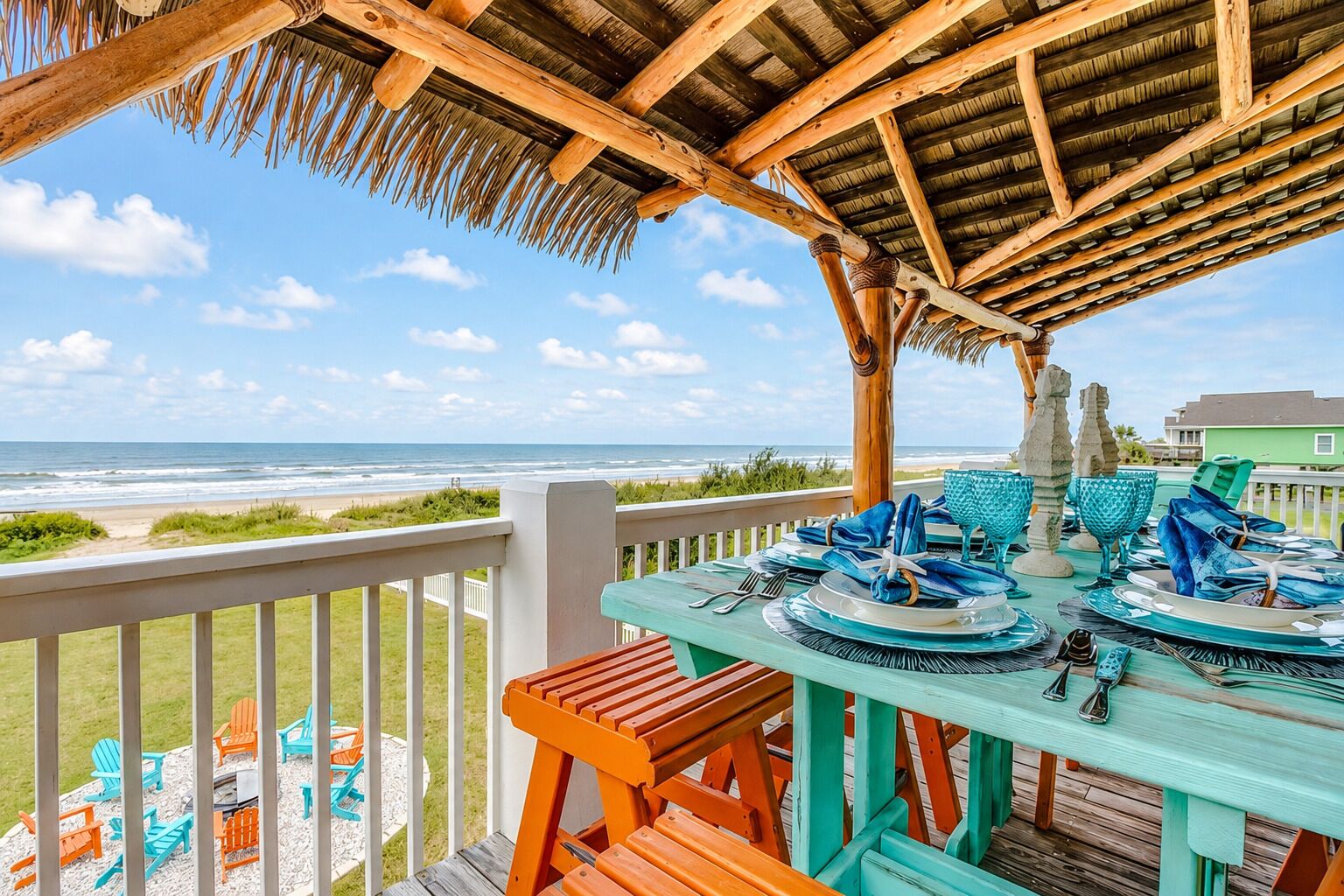 A wooden deck with a table set for dining, overlooking a beach.